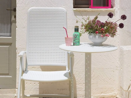 Tavolino per esterni con piano tondo caratterizzato da forellini decorativi, base a tre gambe, facile da montare e smontare, proposto con un kit che permette di ottenere due altezze Step di Nardi